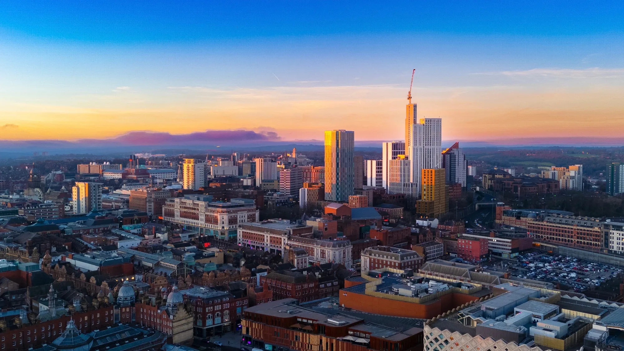 Panoramic view of the Leeds skyline at sunset, showcasing the city's iconic architecture and vibrant cityscape.