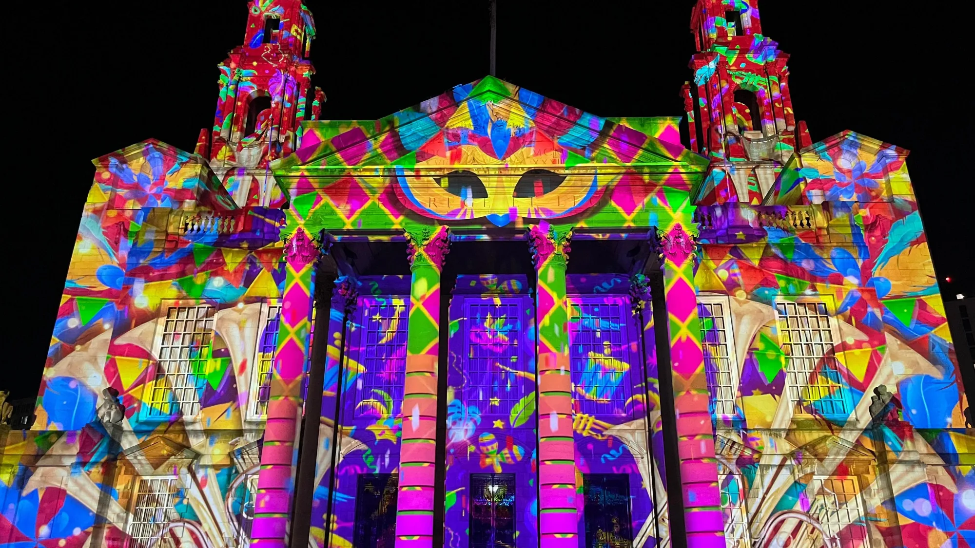 Colourful light projections covering the façade of Leeds Civic Hall during Light Night Leeds, creating a vibrant illuminated display against the night sky.